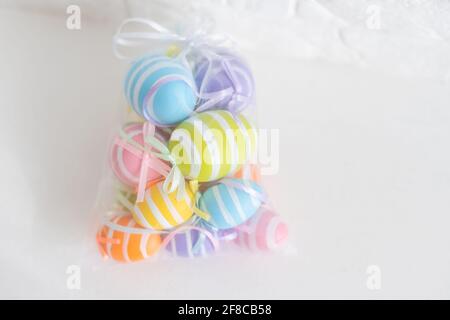 multi-colored chicken eggs in bag mesh on white background. easter Stock Photo