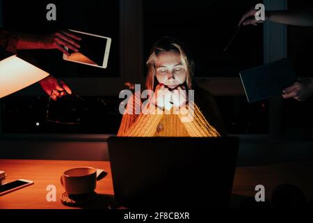 Caucasian female tired student working on. team project sitting at laptop late at night falling asleep in hands  Stock Photo