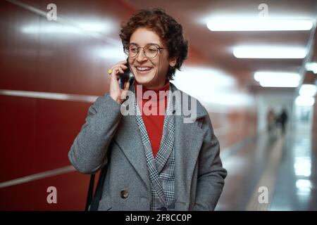 businesswoman with a smartphone in an empty subway underpass. Stock Photo