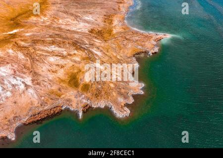 Aerial view about rocky seashore with turquoise waving water. Stock Photo