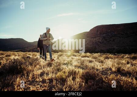 Group of caucasian teens walking happily through beautiful mountain setting Stock Photo