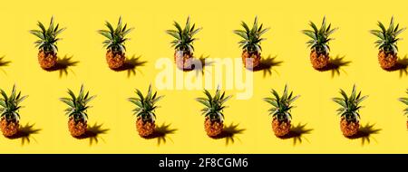 Many pineapples on a solid yellow background pattern Stock Photo