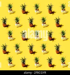 Many pineapples on a solid yellow background pattern Stock Photo