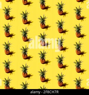 Many pineapples on a solid yellow background pattern Stock Photo