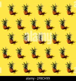 Many pineapples on a solid yellow background pattern Stock Photo
