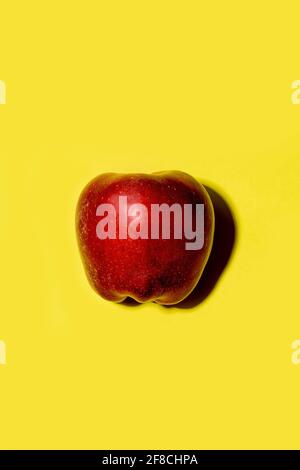 Red apple on a solid yellow background Stock Photo