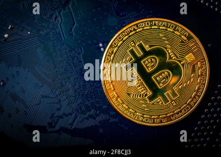 Golden coins with bitcoin symbol on blue mainboard circuit background. Cryptocurrency, Money coin digital. Blockchain technology, bitcoin mining. Stock Photo