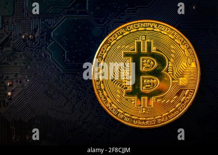 Golden coins with bitcoin symbol on blue mainboard circuit background. Cryptocurrency, Money coin digital. Blockchain technology, bitcoin mining. Stock Photo