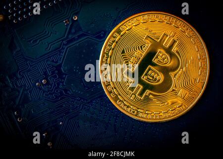 Golden coins with bitcoin symbol on blue mainboard circuit background. Cryptocurrency, Money coin digital. Blockchain technology, bitcoin mining. Stock Photo