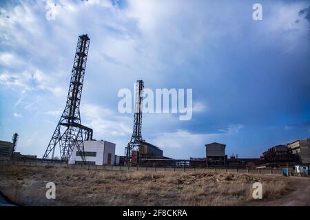 Outdated Soviet plant chmneys on blue sky background. Stock Photo