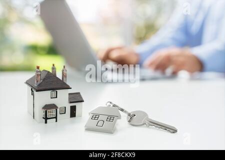 Searching the internet for real estate or new house with model home and key Stock Photo