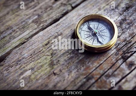 Antique golden compass on wood background concept for direction, travel, guidance or assistance Stock Photo