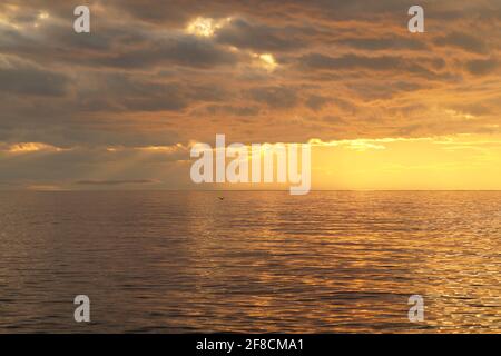 The rays of the setting sun break through the clouds on Lake Bai Stock Photo