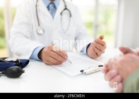 Doctor and patient taking notes in medical surgery Stock Photo