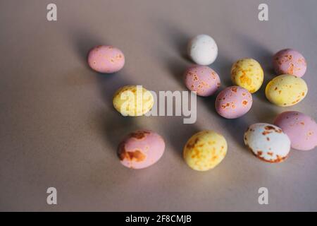 small colored chocolate eggs on a gray background Stock Photo