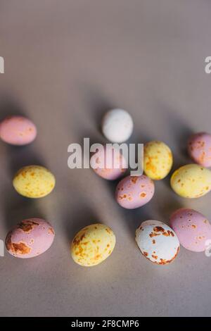 small colored chocolate eggs on a gray background Stock Photo