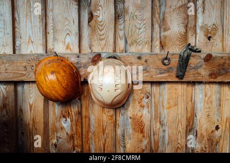 construction helmets hang on a hook on the wall. head protection in hazardous production. workers ' uniforms Stock Photo