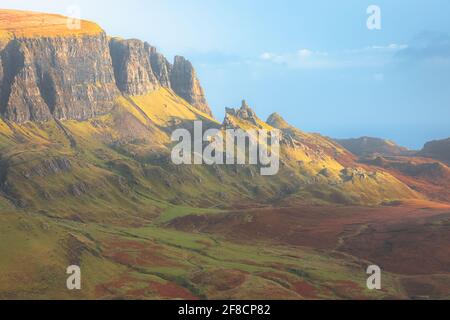 Vibrant golden light at sunset or sunrise over colourful landscape view of the rugged, otherworldly terrain of the Quiraing on the Isle of Skye, Scotl Stock Photo