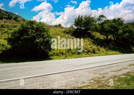 Close up of road in mountainous terrain. Asphalt road going through mountains in summertime Stock Photo