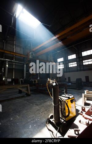 Kazakhstan, Nur-sultan. Locomotive-building plant workshop scenic view. Smoke of welding, apparatus and ray of light. Stock Photo