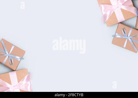 Frame made of gift boxes on a blue pastel background. Present tied ribbon. Preparation for holidays concept with copyspace. Stock Photo