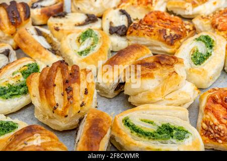 Homemade baking concept, mini pizza rolls, puff pastry rolls snacks with cheese and with black and green olives. High quality photo Stock Photo