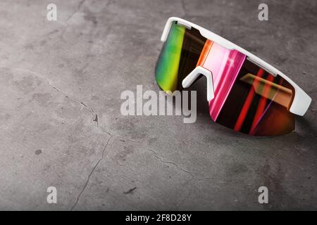 Sports glasses with a red mirrored lens and white frames on a black background. Free space Stock Photo
