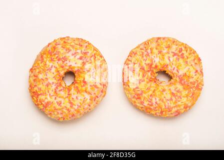 Colourful iced ring doughnuts with sprinkles. Stock Photo