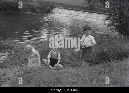 1960s TWO BOYS PITCHER AND CATCHER IN LITTLE LEague baseball uniforms  having a conversation on the pitcher's mound - b14306 HAR001 HARS B&W  PITCHER CATCHER RECREATION MOUND DIRECTION ON THE ATHLETES BALL