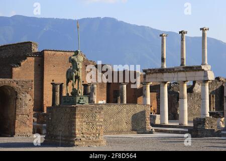 Centaur statue at the Civic Forum of Pompeii with columns on the background excavated after the ancient Roman was destroyed by Mount Vesuvius eruption Stock Photo