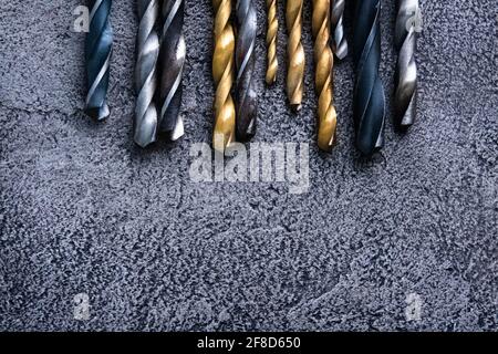 Different sizes drill bits on grey background with copy space Stock Photo