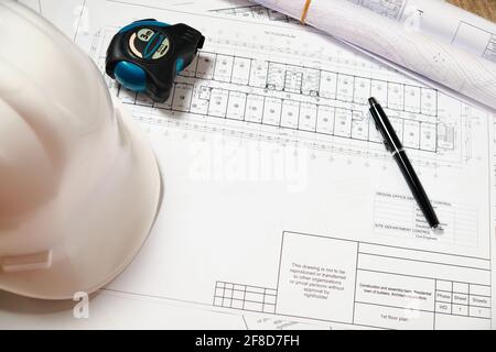 Hardhat, blueprint, measuring tape and pen Stock Photo