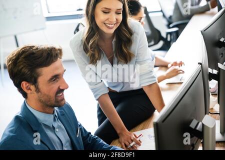 Happy business people having fun and chatting at workplace office Stock Photo