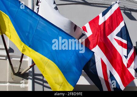 Ukrainian and United Kingdom flags waving on the wall of house Stock Photo