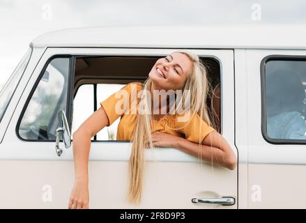 Happy blond woman with closed eyes sitting on a driver seat Stock Photo
