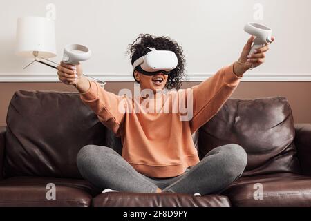 Cheerful mixed race woman sitting on a couch Stock Photo