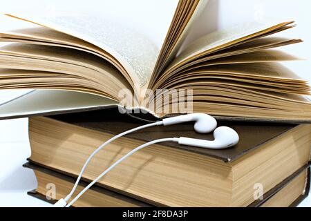 audio headphones on stack of old yellowed hardback books Stock Photo