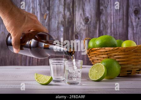 Bottle of pouring sugarcane liquor, a strong typical Brazilian alcoholic drink similar to rum, made in Brazil from the juice of the sugar cane, in a s Stock Photo