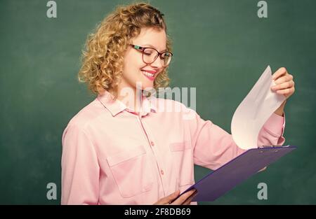 Doing research. teacher with document folder. happy student in glasses at blackboard. girl teacher at school lesson. new school year. Girl prepare for Stock Photo