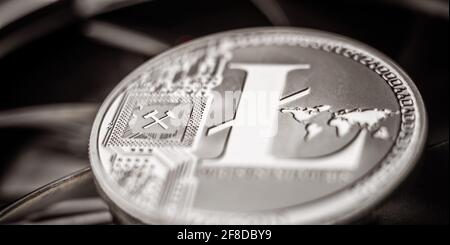 Close-up of physical metal litecoin coin lying on dark background Stock Photo