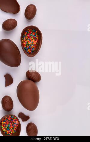 Vertical shot chocolate eggs with rainbow sprinkles. Stock Photo
