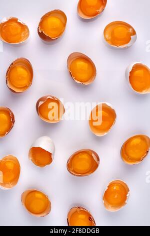 Many cracked eggshells with yolk. Stock Photo
