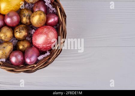 Colored easter eggs in a wicker basket. Stock Photo
