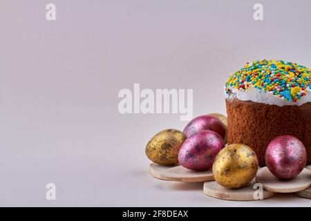 Cupcake with sweet icing and colored eggs on white background. Stock Photo