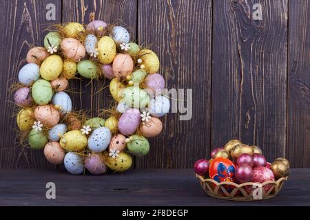 Pile of colored decorative eggs on dark wood. Stock Photo
