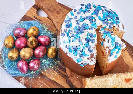 Shiny ester eggs are on the blue nest decoration. Stock Photo