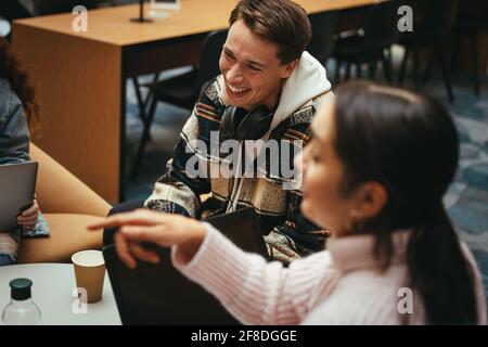 Boys and girls hanging out in college. Cheerful students having fun time in high school. Stock Photo