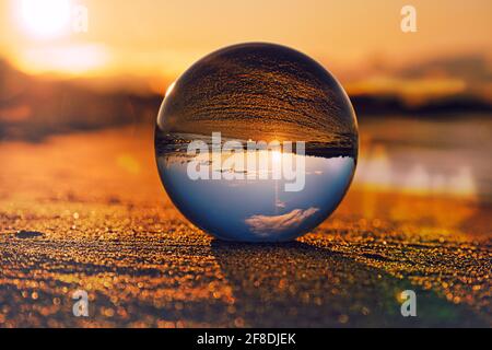 Seeing through with the glass ball. The world viewed through the glass ball. Other perspectives on the Baltic Sea in Zingst. In a beautiful light mood Stock Photo