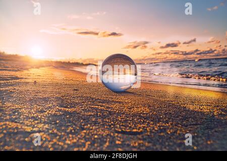 Seeing through with the glass ball. The world viewed through the glass ball. Other perspectives on the Baltic Sea in Zingst. In a beautiful light mood Stock Photo