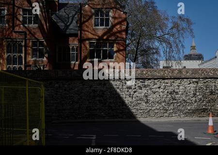 Long Shadow and sunshine over old grey brick wall and old red brick building in london Stock Photo